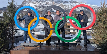 Glice team members at the Cortina Olympic rings during the Winter Olympics activation