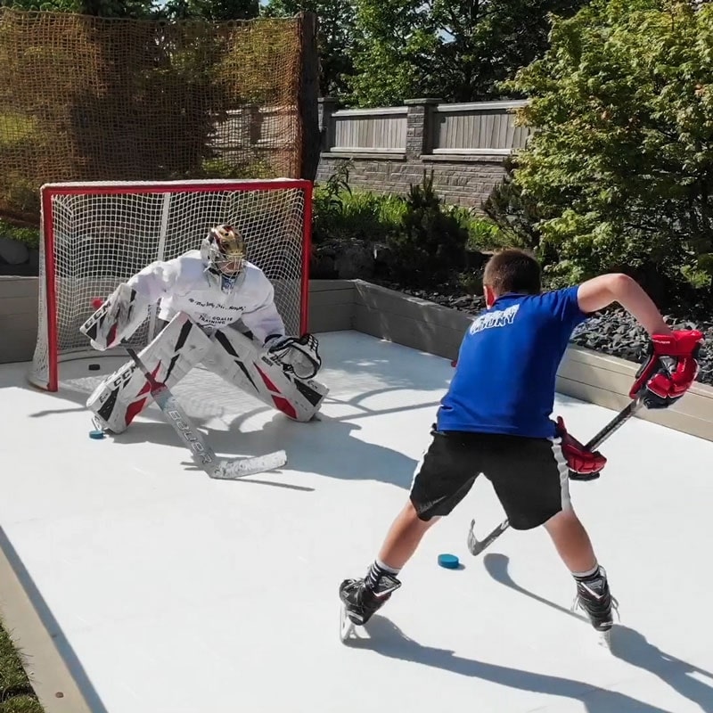 Boys playing hockey on synthetic ice rink