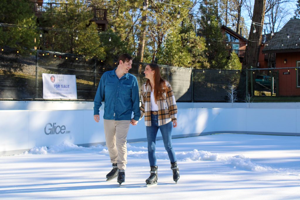 couple ice skating together and smiling